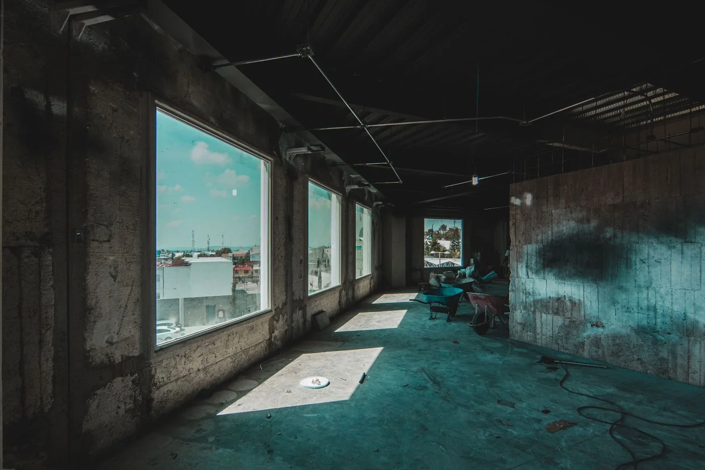 Espaço de uso comercial com grandes janelas e interior em construção.